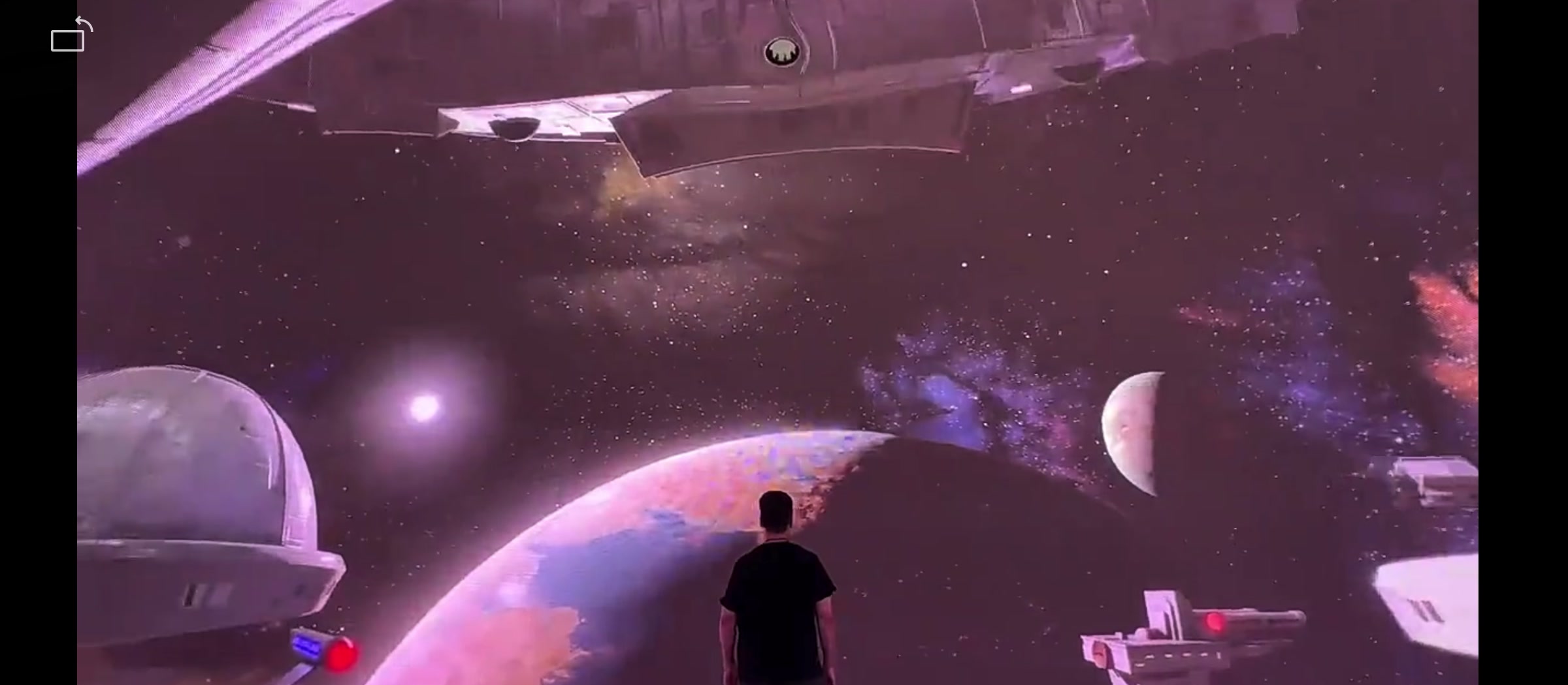 Person inside walk-in LED dome surrounded by space